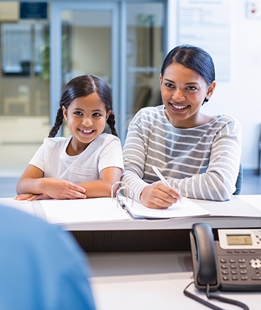 Mother and child checking in at reception desk