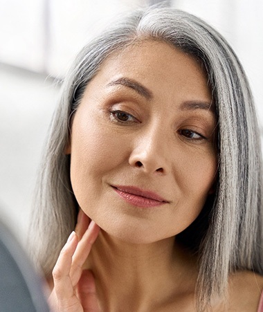 Happy Springfield patient looking in mirror at smoother face