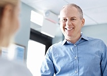 Smiling man at dental reception desk