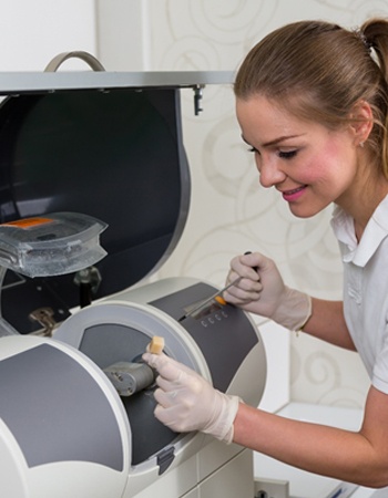 Dental team member placing ceramic cube into the milling system