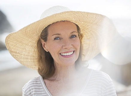 An older woman wearing a large hat and smiling after seeing her Delta Dental dentist in Springfield