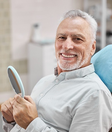 senior man smiling after getting dentures in Springfield