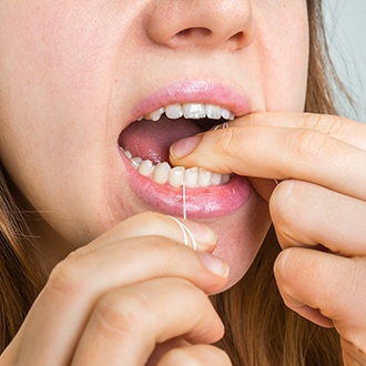 woman flossing teeth