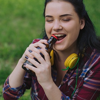 woman trying to open beverage bottle with teeth