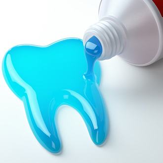 toothpaste spilling out of a tube into the shape of a tooth