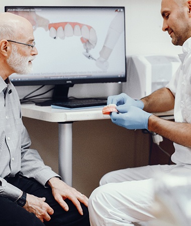 An implant dentist in Springfield discussing a male patient’s eligibility for treatment