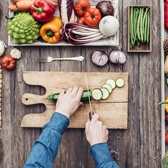 Man surrounded by assortment of foods preparing dinner