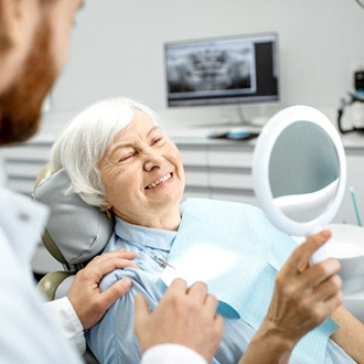 Woman examining her dental implants in Springfield with a dentist