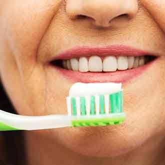 : a woman flossing her dental implants