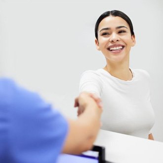 a woman shaking hands with a dental assistant