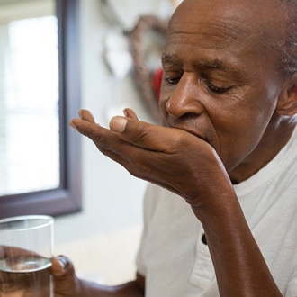 older man taking medicine