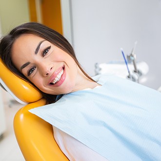 Woman smiling while sitting in treatment chair
