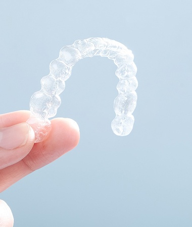 Invisalign aligner next to blue case 