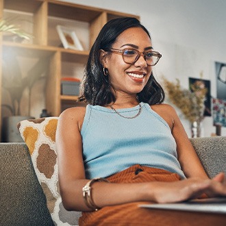 Woman smiling while working on laptop at home
