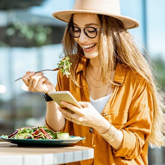 Woman smiling while eating lunch outside