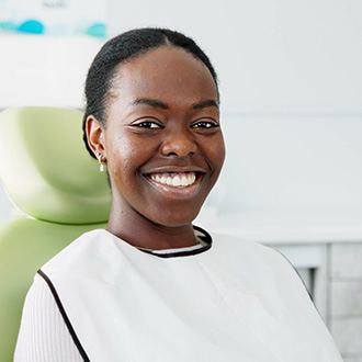 Woman smiling while sitting in treatment chair