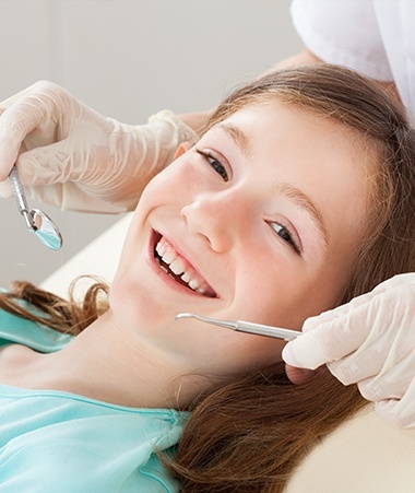 Smiling child in dental chair for children's dentistry treatment