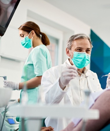 Dentist smiling at patient sitting in treatment chair