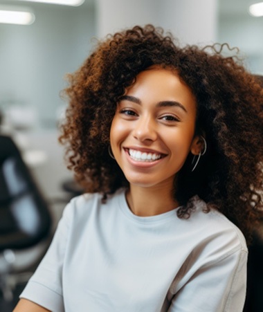 Woman smiling while sitting in dentist's treatment chair