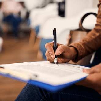 woman filling out dental insurance form in lobby