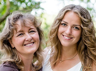 Smiling mother and daughter after orthodontic treatment
