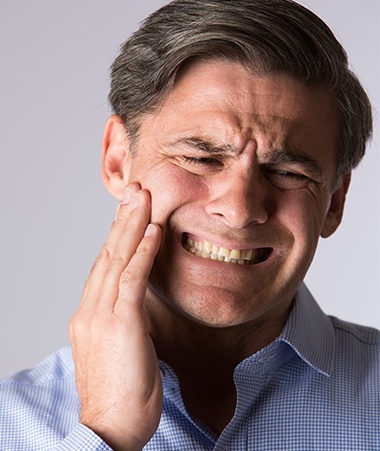 Man in pain holding jaw