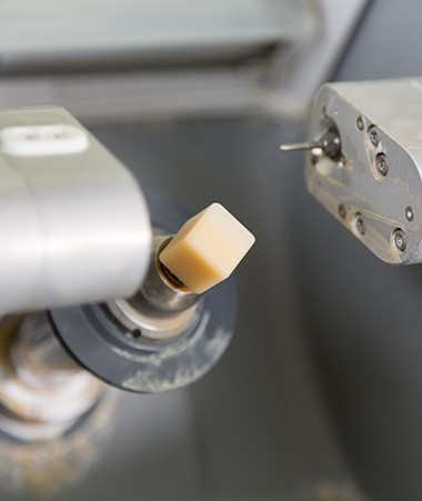 Dental team member placing porcelain cube in CEREC milling unit