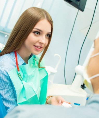 A young woman talking to her dentist about porcelain veneers