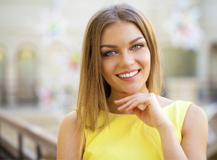 A young woman smiling after porcelain veneer treatment