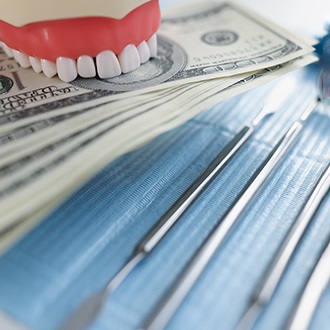 a model of teeth biting down on money