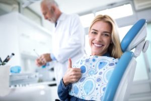 woman giving thumbs up while in dental chair