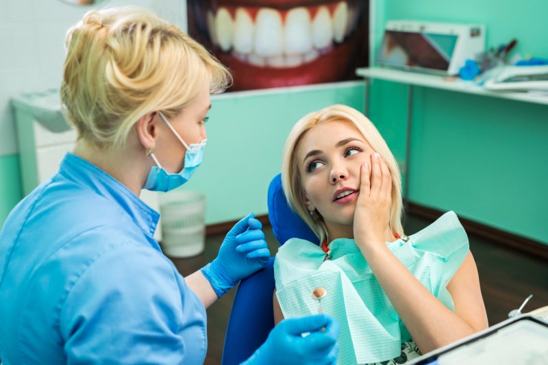 a woman in pain at the dentist office