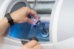Person making same-day crown using CEREC machine.