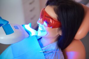 Woman in dentist’s chair getting teeth whitened.